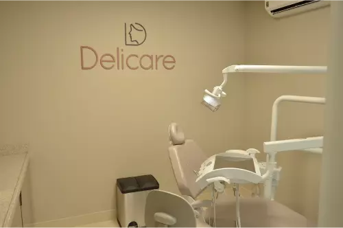 Consultório da Delicare com cadeira odontológica e logo na parede