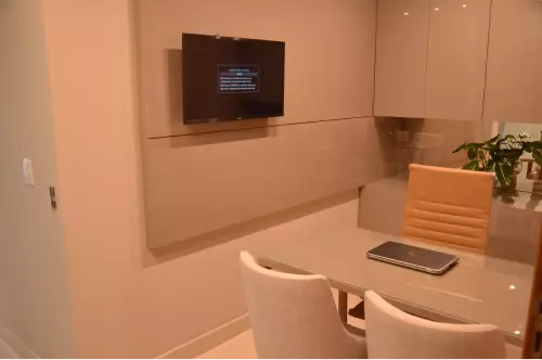 Sala de consulta da Delicare com TV e mesa de atendimento