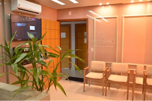 Sala de espera da Delicare Odontologia, em Betim, com poltronas e plantas